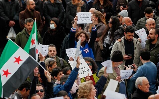 Des manifestants brandissent des pancartes lors d'une manifestation contre les nouvelles restrictions sur l'alcool, qui limitent la vente principalement aux quartiers chrétiens de Damas, en Syrie, le 22 mars 2026. (Crédit : AP/Omar Sanadiki)