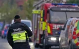 Un membre d'une organisation de sécurité communautaire surveille l'équipe des pompiers de Londres, le 23 mars 2026, après l'incendie. criminel de nature manifestement antisémite de quatre véhicules appartenant au service d'ambulance juif, Hatzola Northwest, à Londres. (Photo AP/Alberto Pezzali)