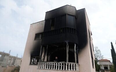 Un Palestinien se tenant sur le balcon d'une maison incendiée à la suite des violences perpétrées par des résidents d'implantations, dans les villages voisins de la région de Naplouse la veille au soir, dans le village de Deir al-Hatab, en Cisjordanie, le 23 mars 2026. (Crédit : Majdi Mohammed/AP) Un Palestinien se tenant sur le balcon d'une maison incendiée à la suite des violences perpétrées par des résidents d'implantations, dans les villages voisins de la région de Naplouse la veille au soir, dans le village de Deir al-Hatab, en Cisjordanie, le 23 mars 2026. (Crédit : Majdi Mohammed/AP)
