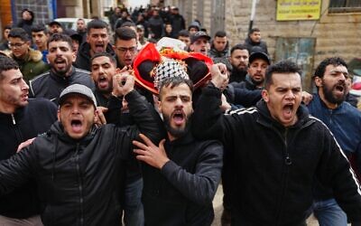 Des pleureurs portant le corps du Palestinien Mustafa Hamad, 22 ans, lors de ses funérailles dans le camp de réfugiés de Qalandiya, en Cisjordanie, le 27 mars 2026. (Crédit : Mahmoud Illean/AP)