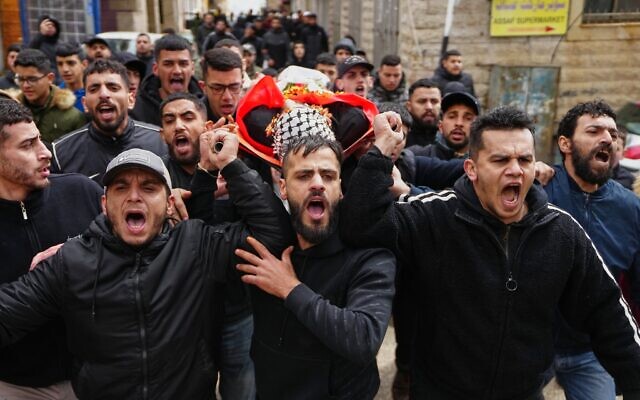 Des pleureurs portant le corps du Palestinien Mustafa Hamad, 22 ans, lors de ses funérailles dans le camp de réfugiés de Qalandiya, en Cisjordanie, le 27 mars 2026. (Crédit : Mahmoud Illean/AP)