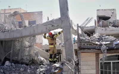 Un secouriste inspecte la structure endommagée d'un immeuble résidentiel touché lors d'une précédente frappe américano-israélienne à Téhéran, le 27 mars 2026. (Crédit: AP Photo/Vahid Salemi)