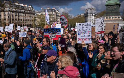 Des manifestants brandissant des banderoles participent à la manifestation « No Kings » à Paris, le 28 mars 2026. (Crédit : Aurélien Morissard/AP Photo)