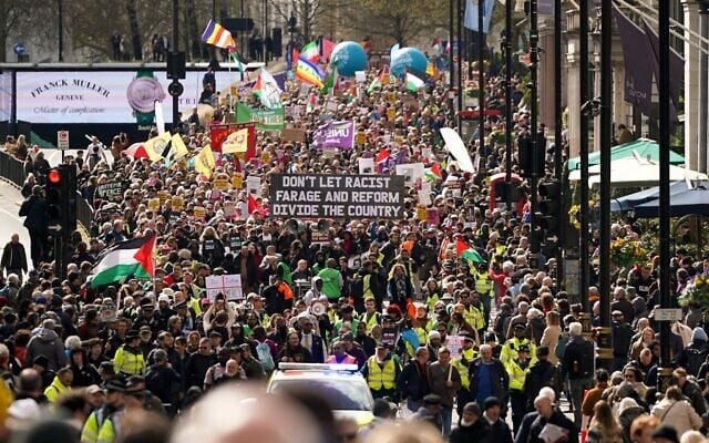 Des manifestants brandissent des pancartes et des banderoles lors de la manifestation « Ensemble contre l'extrême-droite », à Londres, le 28 mars 2026. (Crédit : Alberto Pezzali/AP)