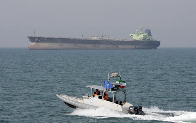 Photo d'illustration : un hors-bord des Gardiens de la révolution islamique navigue dans le golfe Persique, avec un pétrolier en arrière-plan. (Crédit : AP Photo/Vahid Salemi)