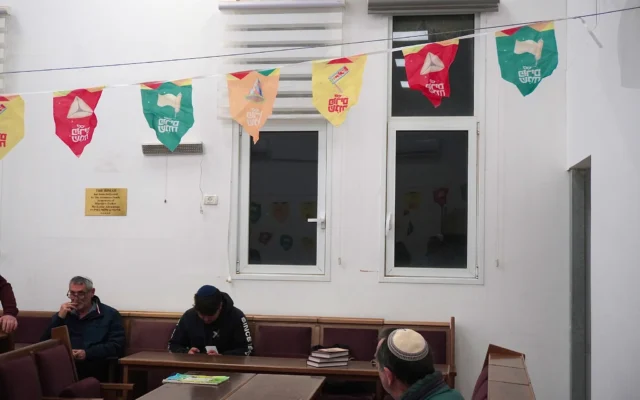 Les habitants de Beit Shemesh assistent à la lecture de la megillah de Pourim le 2 mars 2026. (Crédit: Charlie Summers/Times of Israel)