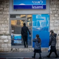 Des passants devant une agence de la banque Leumi, à Jérusalem, le 5 février 2024. (Crédit : Chaïm Goldberg/Flash90)