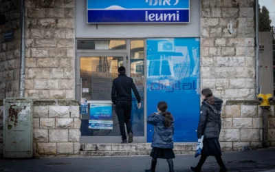 Des passants devant une agence de la banque Leumi, à Jérusalem, le 5 février 2024. (Crédit : Chaïm Goldberg/Flash90)