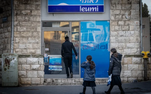 Des passants devant une agence de la banque Leumi, à Jérusalem, le 5 février 2024. (Crédit : Chaïm Goldberg/Flash90) Des passants devant une agence de la banque Leumi, à Jérusalem, le 5 février 2024. (Crédit : Chaïm Goldberg/Flash90)
