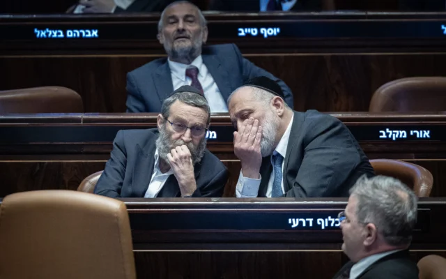 Le chef du parti Shas, le député Aryeh Deri, à droite, s'entretient avec le numéro 2 du parti Yahadout HaTorah, le député Moshe Gafni, lors d'une séance plénière de la Knesset à Jérusalem, le 10 février 2025. (Yonatan Sindel/Flash90)