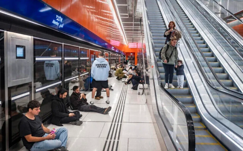 Des personnes se réfugient dans une gare souterraine à Tel Aviv, lors d'attaques de missiles iraniens, le 28 février 2026 (Chaim Goldberg/Flash90)
