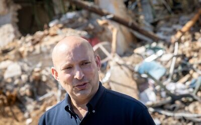 Photo : Naftali Bennett sur le lieu d'un impact de missile balistique à Tel-Aviv, le 1er mars 2026 (Crédit : Chaim Goldberg/Flash90)