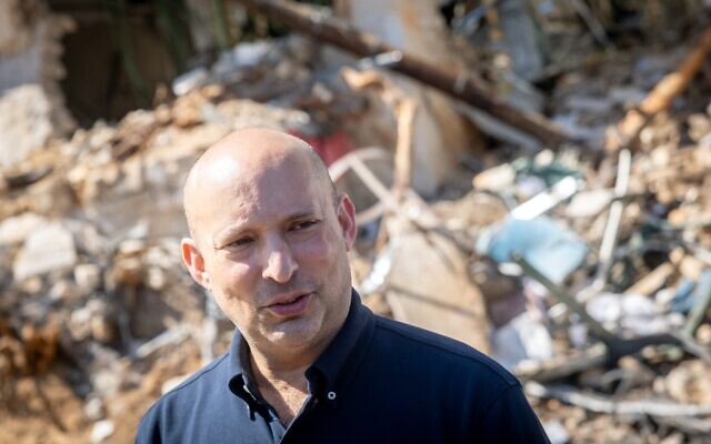 Photo : Naftali Bennett sur le lieu d'un impact de missile balistique à Tel-Aviv, le 1er mars 2026 (Crédit : Chaim Goldberg/Flash90)