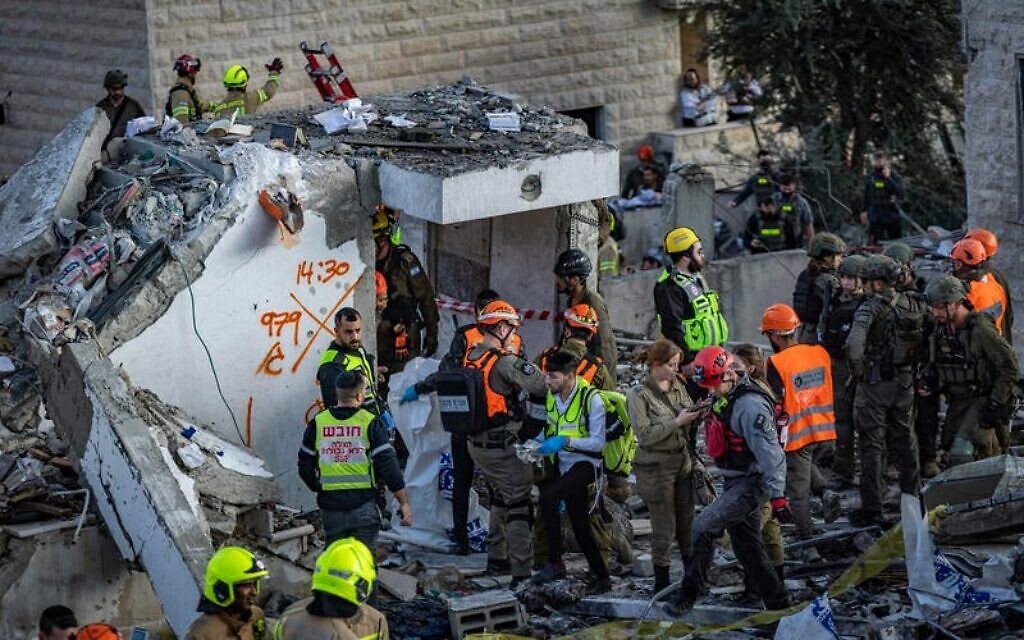 Les forces de sécurité et de secours intervenant sur les lieux où un missile balistique tiré depuis l'Iran a frappé Beit Shemesh, dans le centre d'Israël, causant d'importants dégâts et faisant au moins huit morts, le 1ᵉʳ mars 2026. (Crédit : Yonatan Sindel/Flash90)