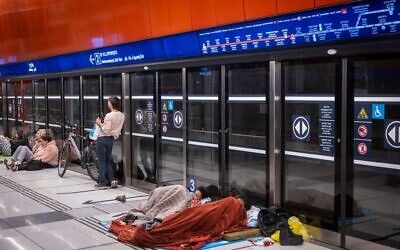 Des personnes réfugiées dans une station de métro, à Tel Aviv, le 7 mars 2026. (Crédit : Chaïm Goldberg/Flash90)