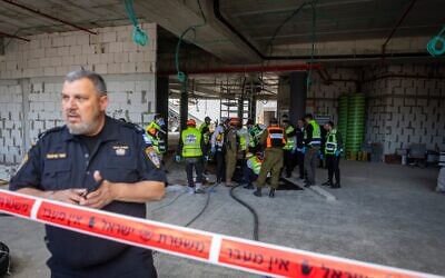 Premiers intervenants sur les lieux d'un impact de missile mortel sur un chantier de construction à Yehud, le 9 mars 2026. (Crédit : Chaim Goldberg/Flash90)