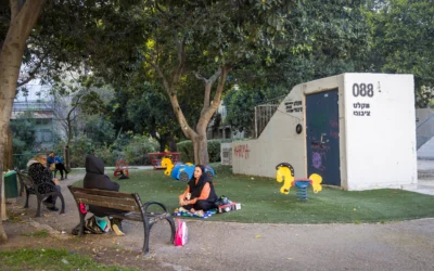 Des personnes sont assises devant un abri anti-bombe public à Haïfa, le 10 mars 2026. (Crédit : Yossi Aloni/Flash90)