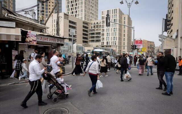 Des clients évacuant le marché Mahane Yehuda de Jérusalem et cherchant un abri alors que la sirène d'alerte aérienne retentit, le 13 mars 2026. (Crédit : Chaïm Goldberg/Flash90)