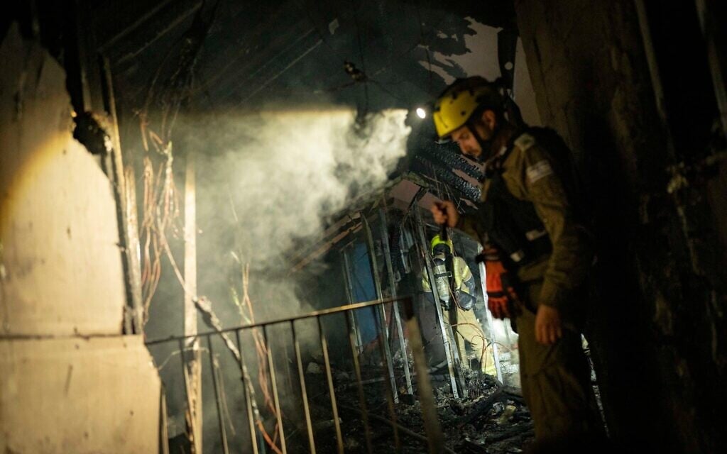 Les forces de sécurité et de secours israéliennes sur les lieux où un missile tiré depuis l'Iran a causé des dégâts à Shoham, le 13 mars 2026. (Crédit : Flash90)