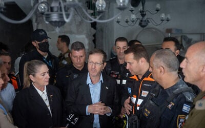 Le président israélien Isaac Herog et son épouse Michal sur les lieux où un missile tiré d'Iran vers Israël a endommagé une maison à Rishon le Tzion, le 16 mars 2026. (Crédit : Chaim Goldberg/Flash90)