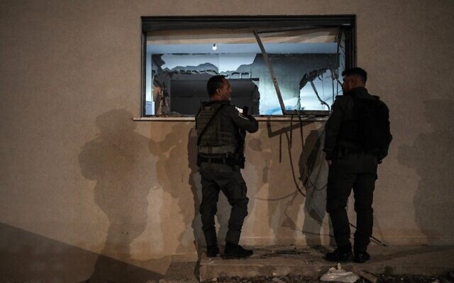 Les forces de sécurité israéliennes sur les lieux où un missile tiré depuis l'Iran a endommagé une maison à Neta, dans le centre-sud d'Israël, le 18 mars 2026 (Crédit : Tsafrir Abayov/Flash90)
