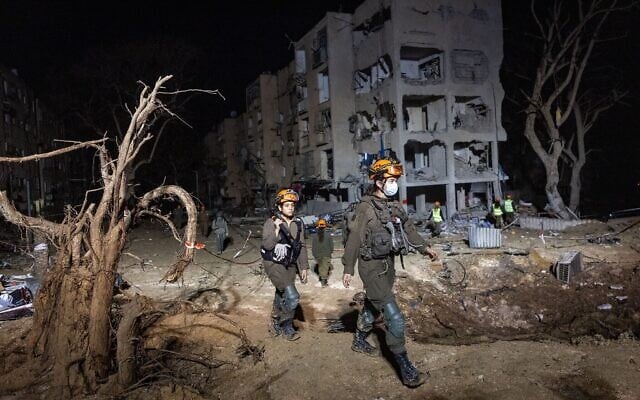 Les forces de sécurité et de secours israéliennes sur les lieux où un missile tiré depuis l'Iran en direction d'Israël a endommagé des immeubles, dans la ville d'Arad, dans le sud du pays, le 22 mars 2026. (Crédit : Chaïm Goldberg/Flash90) Les forces de sécurité et de secours israéliennes sur les lieux où un missile tiré depuis l'Iran en direction d'Israël a endommagé des immeubles, dans la ville d'Arad, dans le sud du pays, le 22 mars 2026. (Crédit : Chaïm Goldberg/Flash90)