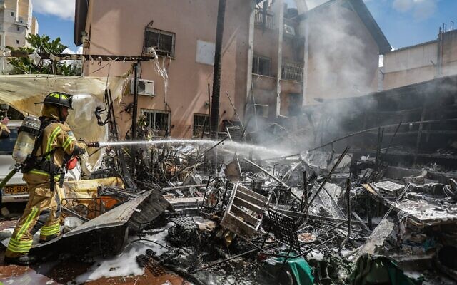 Les forces de sécurité et de secours israéliennes sur les lieux où un missile tiré depuis l'Iran en direction d'Israël a causé des dégâts, à Petah Tikva, le 22 mars 2026. (Crédit : Tal Gal/Flash90)