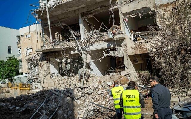 Les forces de sécurité et de secours israéliennes sur les lieux où un missile tiré depuis l'Iran en direction d'Israël a causé des dégâts, à Tel Aviv, le 24 mars 2026. (Crédit : Flash90)
