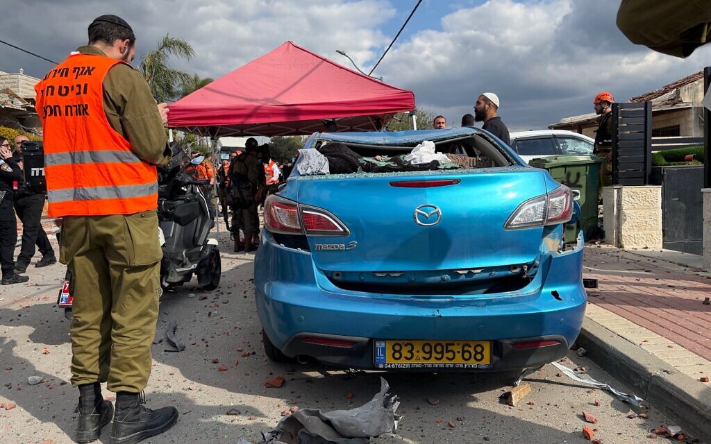 Un soldat de l'armée israélienne se tient à côté d'une voiture détruite lors d'une frappe de missile iranien à Beit Shemesh, le 1er mars 2026. (Crédit : Sam Sokol/Times of Israel)