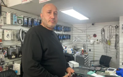 L'avocat Samy Faisal, qui ne peut pas représenter ses clients car les tribunaux ne traitent aucune affaire avant le 14 avril, achète un téléphone portable pour sa mère dans la ville de Haïfa, au nord du pays, le 24 mars 2026. (Crédit : Sue Surkes/Times of Israel)
