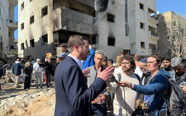 Le porte-parole du ministère des Affaires étrangères, Oren Marmorstein, s'adressant aux journalistes sur le site d'une attaque au missile iranien ayant touché un immeuble, dans le centre de Tel Aviv, le 1ᵉʳ mars 2026. (Crédit : Nava Freiberg/Times of Israel)