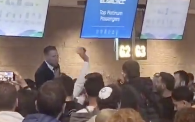 Des personnes entourent un comptoir d'enregistrement à l'aéroport Ben Gourion près de Tel Aviv alors qu'un passager en partance interpelle un employé de l'aéroport, le 9 mars 2026. (Crédit : Capture d'écran : X, utilisée conformément à la clause 27a de la loi sur le droit d'auteur)