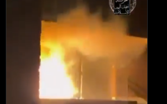 Une image extraite d’une vidéo comportant un logo et des inscriptions en arabe attribués au groupe « Ashab al-Yamin », montrant la porte en feu de la synagogue de Rotterdam, diffusée sur X, le 13 mars 2026. vidéo (Crédit : Capture d’écran/X)