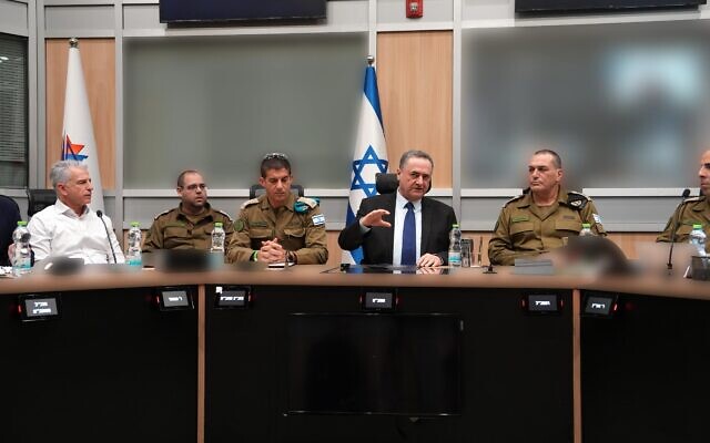 Le ministre de la Défense Israël Katz (au centre) est photographié en compagnie du chef d'état-major de l'armée israélienne, le lieutenant-général Eyal Zamir (à droite), de son secrétaire militaire, le général de brigade Guy Markizeno (2e à partir de la gauche) et du chef du Mossad David Barnea (à gauche), au centre de commandement souterrain de l'armée israélienne, au quartier général militaire de Tel Aviv, le 1er mars 2026. (Crédit : Ariel Hermoni/Ministère de la Défense)