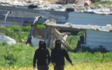 Des résidents d'implantations extrémistes menaçant des militants palestiniens bédouins ainsi que des militants israéliens des droits de l'Homme dans des hameaux bédouins des environs de Mukhmas, en Cisjordanie, le 8 mars 2026. (Crédit : Torat Tzedek)