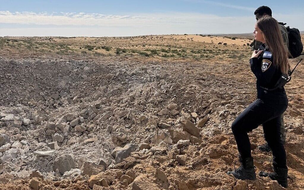 Des agents de la police israélienne sur les lieux de l'impact d'un missile balistique iranien, dans le Néguev, le 28 mars 2026. (Crédit : Police israélienne)