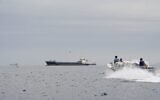 Des navires et un bateau dans le détroit d'Ormuz, au large des côtes d'Oman, le 12 avril 2026. (Crédit : Reuters)