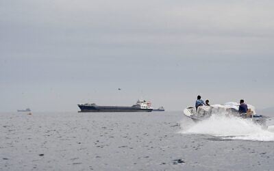 Des navires et un bateau dans le détroit d'Ormuz, au large des côtes d'Oman, le 12 avril 2026. (Crédit : Reuters)