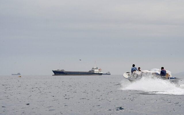 Des navires et un bateau dans le détroit d'Ormuz, au large des côtes d'Oman, le 12 avril 2026. (Crédit : Reuters)