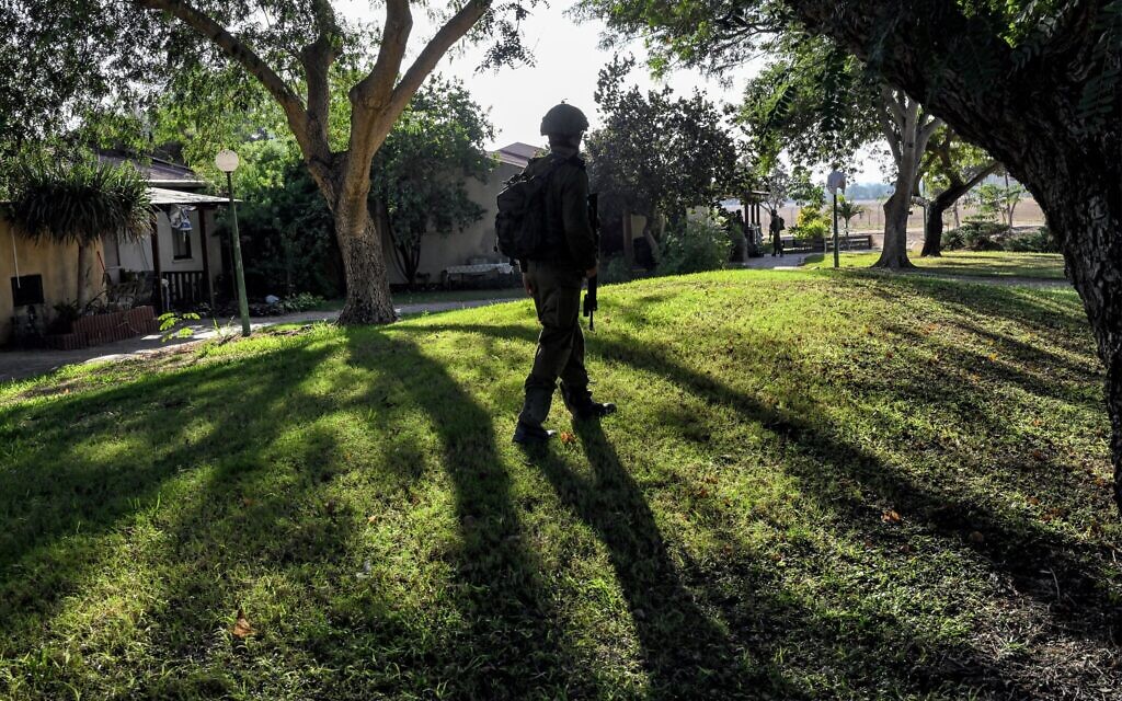 Un soldat israélien passant devant une maison attaquée par des terroristes palestiniens le 7 octobre, au kibboutz Holit, le 26 octobre 2023. (Crédit : Yuri Cortez/AFP)