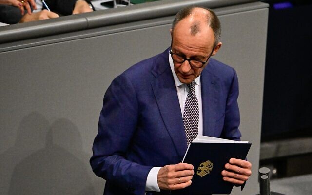 Le chancelier allemand Friedrich Merz quittant la salle après avoir prononcé un discours sur la politique étrangère, au Bundestag, à Berlin, le 29 janvier 2026. (Crédit : Tobias Schwarz/AFP)