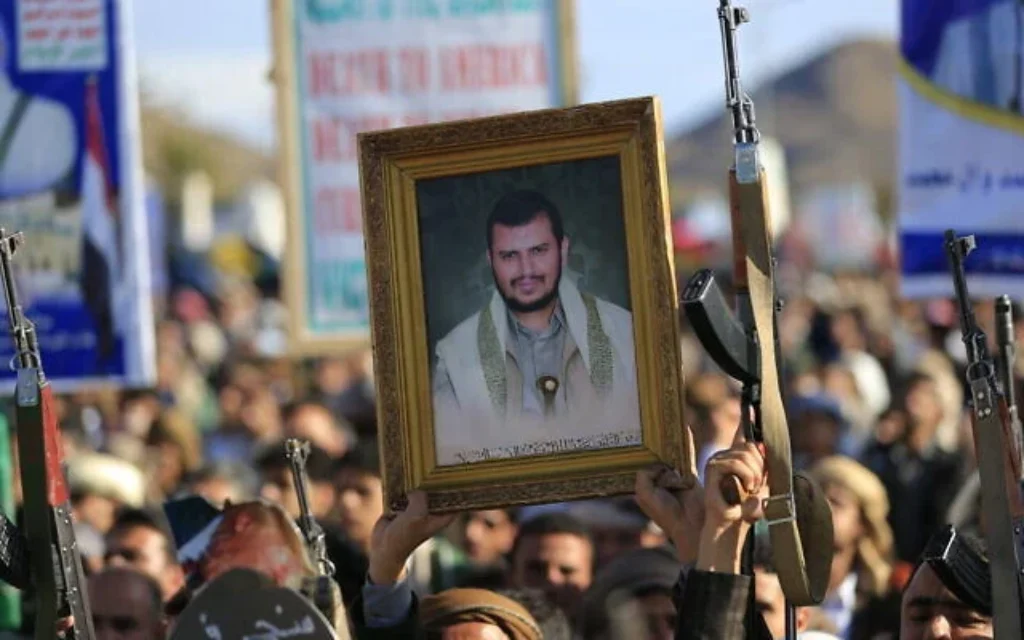 Un partisan des Houthis du Yémen tient une photo de leur chef Abdul-Malik al-Houthi alors que d'autres brandissent leurs armes tout en se mobilisant en solidarité avec l'Iran et le Hezbollah libanais, dans le cadre de la guerre américano-israélienne contre l'Iran à Sanaa, la capitale du Yémen, le 27 mars 2026. (Mohammed Huwais/AFP)