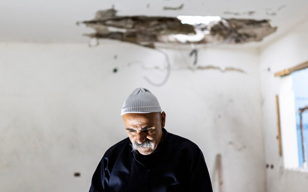 Un membre de la communauté druze d'Israël évaluant les dégâts causés à un bâtiment touché dans la nuit par une roquette tirée depuis le Liban, dans la ville de Shfaram, à l'est de Haïfa, dans le nord d'Israël, le 2 avril 2026 (Crédit : Ilia Yefimovich/AFP)