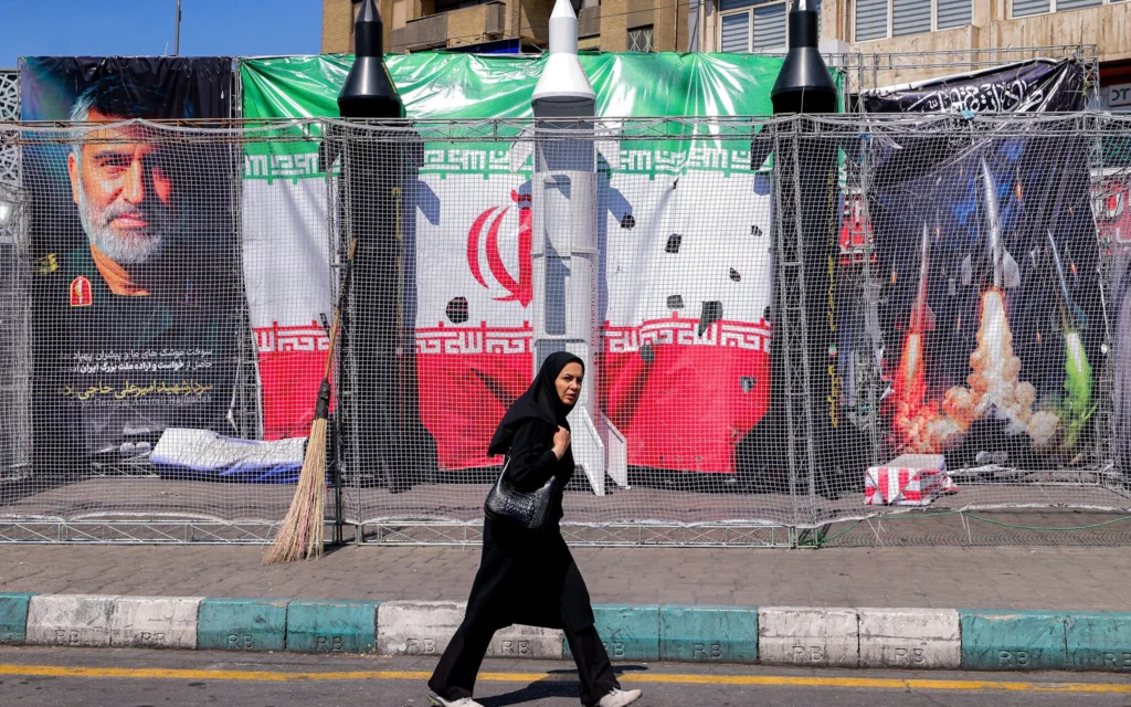 Une femme passe devant des maquettes de missiles iraniens sur la place Valiasr à Téhéran, le 6 avril 2026. (Crédit : Atta Kenare/AFP)