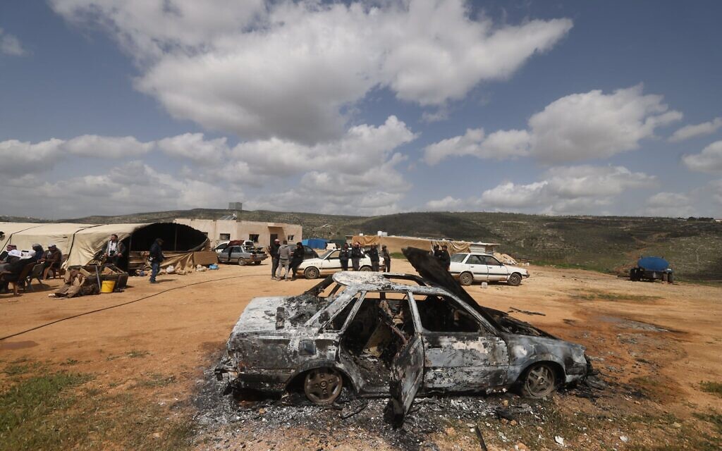 Des Palestiniens se tiennent près d'un véhicule détruit à la suite d'une attaque menée par des résidents d'implantations à la périphérie du village d'Al-Lubban ash-Sharqiya, au sud de Naplouse, en Cisjordanie, le 6 avril 2026. (Crédit : JAAFAR ASHTIYEH / AFP)
