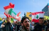 Des partisans du groupe terroriste chiite libanais du Hezbollah, dont certains brandissent le drapeau libanais, manifestant près du palais du Gouvernement pour protester contre la décision des autorités libanaises d'entamer des négociations directes avec Israël afin de mettre fin à la guerre en cours, dans le centre-ville de Beyrouth, le 11 avril 2026. (Crédit : Ibrahim Amro/AFP)