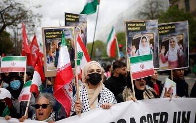 Des manifestants brandissant des drapeaux iraniens lors d'un rassemblement contre le projet de loi Yadan, qui vise à lutter contre les nouvelles formes d'antisémitisme, à Paris, le 12 avril 2026. Ce projet de loi, qui porte le nom de la députée du camp présidentiel Caroline Yadan et sera débattu les 16 et 17 avril prochains, vise à lutter contre les « nouvelles formes » d’antisémitisme et suscite de vives réserves. Ses opposants, notamment à gauche, affirment qu’il menacerait la liberté d’expression et perpétuerait l’amalgame entre les Juifs et Israël. (Crédit : Ian Langsdon/AFP) Des manifestants brandissant des drapeaux iraniens lors d'un rassemblement contre le projet de loi Yadan, qui vise à lutter contre les nouvelles formes d'antisémitisme, à Paris, le 12 avril 2026. Ce projet de loi, qui porte le nom de la députée du camp présidentiel Caroline Yadan et sera débattu les 16 et 17 avril prochains, vise à lutter contre les « nouvelles formes » d’antisémitisme et suscite de vives réserves. Ses opposants, notamment à gauche, affirment qu’il menacerait la liberté d’expression et perpétuerait l’amalgame entre les Juifs et Israël. (Crédit : Ian Langsdon/AFP)
