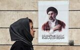 Une Iranienne passant devant une affiche représentant le portrait de Mojtaba Khamenei, le nouveau guide suprême de l'Iran, dans la capitale Téhéran, le 13 avril 2026 (Crédit : Atta Kenare/AFP)
