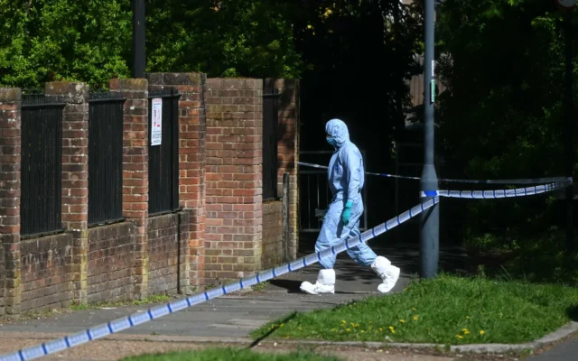 Un expert de la police scientifique dans ur d'un périmètre de sécurité établi près de la Kenton United Synagogue à Harrow, au nord-ouest de Londres, sur les lieux d'un incendie criminel survenu pendant la nuit, le 19 avril 2026. Crédit: (JUSTIN TALLIS / AFP)