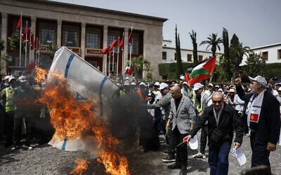 Des manifestants marocains brûlent un drapeau israélien lors d'un rassemblement anti-Israël à Rabat, le 19 avril 2026. (Crédit : Abdel Majid BZIOUAT / AFP)
